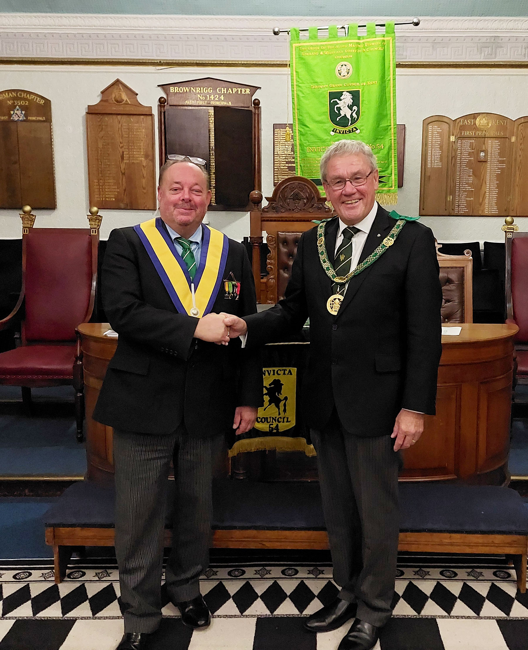 The District Grand Prefect R. W. Bro. Brian Ward congratulates W. Bro. Bill Pennell the new Master of Invicta Council 54